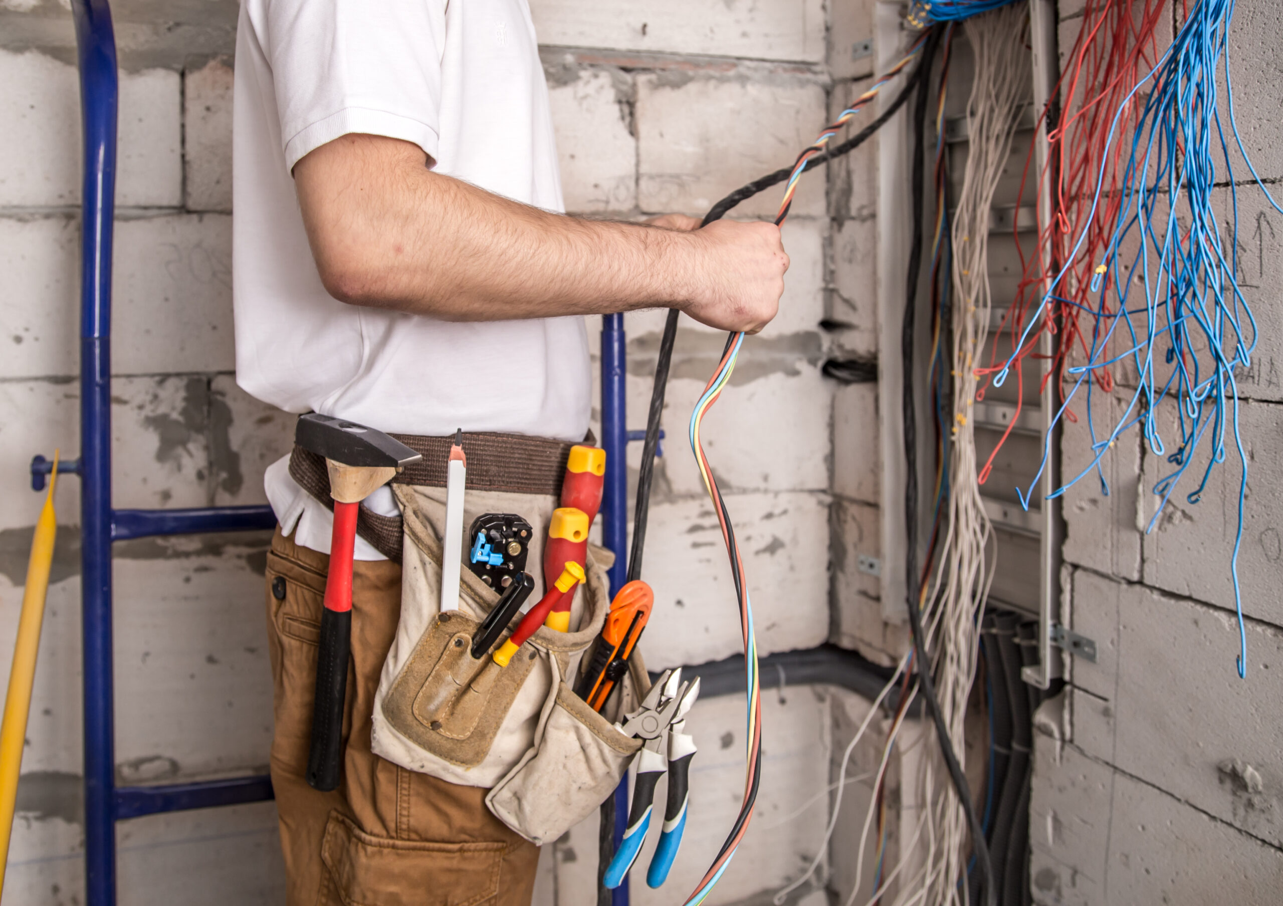 electrician working near the board with wires. installation and connection of electrics.